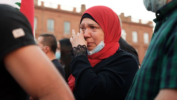 Женщина плачет на собрании в Тулузе, Франция, в поддержку пострадавших от взрыва в Бейруте - Sputnik Латвия
