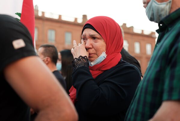 Женщина плачет на собрании в Тулузе, Франция, в поддержку пострадавших от взрыва в Бейруте - Sputnik Латвия