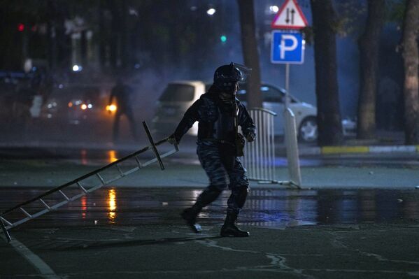 Сотрудник правоохранительных органов во время акции протеста в Бишкеке - Sputnik Латвия