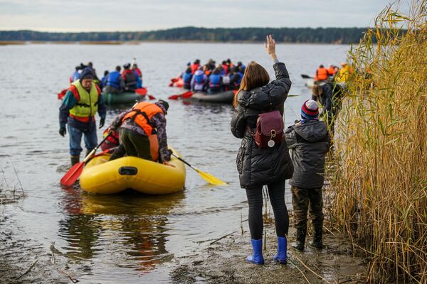 Участники, оставшиеся на берегу, провожают лодки - Sputnik Латвия