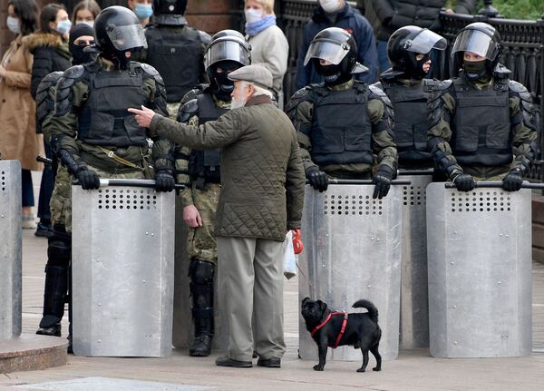 Мужчина разговаривает с сотрудниками милиции во время акции протеста оппозиции Народный ультиматум в Минске - Sputnik Латвия