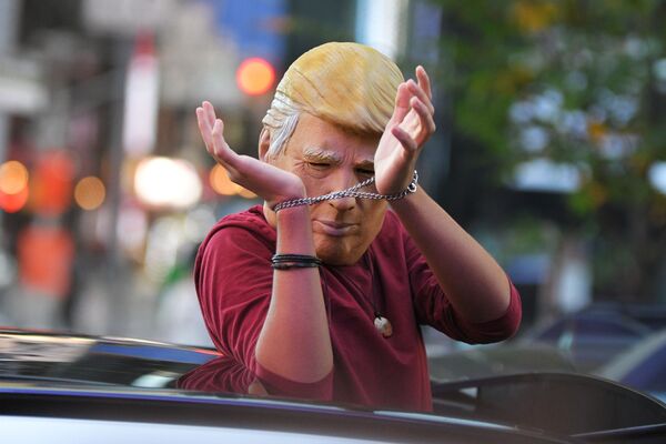 Человек в маске Дональда Трампа едет на машине по улице Нью-Йорка после новостей о победе на выборах президента США кандидата от Демократической партии Джозефа Байдена Человек в маске Дональда Трампа едет на машине по улице Нью-Йорка после новостей о победе на выборах президента США кандидата от Демократической партии Джозефа Байдена - Sputnik Латвия