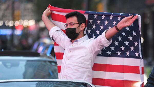 Человек с флагом США на Таймс-сквер в Нью-Йорке после новостей о победе на выборах президента США кандидата от Демократической партии Джозефа Байдена - Sputnik Latvija