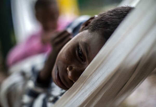 Ребенок отдыхает в гамаке в приюте после эвакуации из-за урагана Йота в Бильви, Никарагуа - Sputnik Латвия