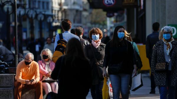 Люди в защитных масках на улице Женевы - Sputnik Latvija