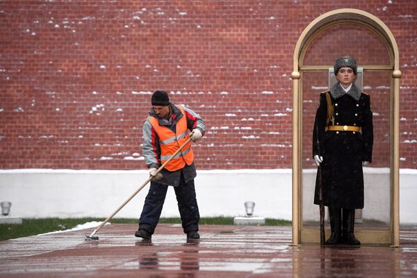 Мужчина убирает снег у Могилы Неизвестного Солдата у стен Московского Кремля - Sputnik Латвия