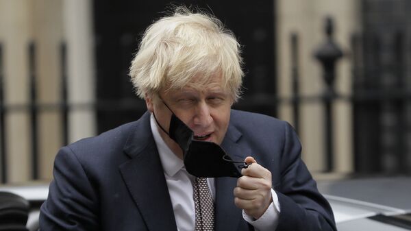 Премьер-министр Великобритании Борис Джонсон снимает маску - Sputnik Латвия