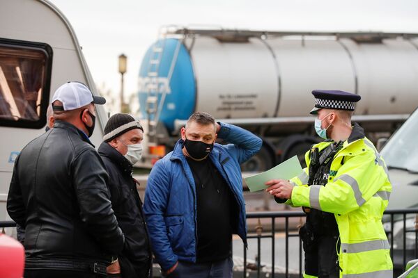 Policists sarunājas ar poļu autovadītājiem pie Duvras ostas un novirza mašīnas uz Manstonas lidostu Policists sarunājas ar poļu autovadītājiem pie Duvras ostas un novirza mašīnas uz Manstonas lidostu - Sputnik Latvija