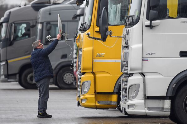 Ungāru tālbraucējs regulē kravas auto antenu stāvvietā Lielbritānijā Ungāru tālbraucējs regulē kravas auto antenu stāvvietā Lielbritānijā - Sputnik Latvija