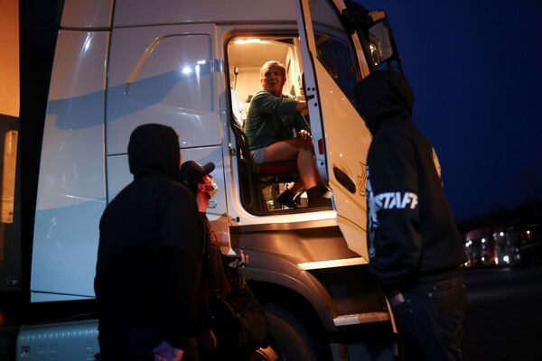 Čehu autovadītājs runājas ar kolēģiem starptautiskajā kravas automašīnu pieturvietā Ešfordā Čehu autovadītājs runājas ar kolēģiem starptautiskajā kravas automašīnu pieturvietā Ešfordā - Sputnik Latvija