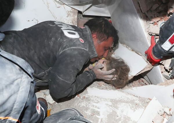 Турецкие спасатели вытаскивают ребенка из под обломков после землетрясения в Измире - Sputnik Латвия