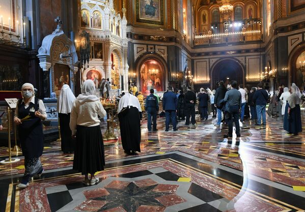 Верующие, соблюдающие социальную дистанцию, во время Рождественского богослужения в храме Христа Спасителя в Москве - Sputnik Latvija