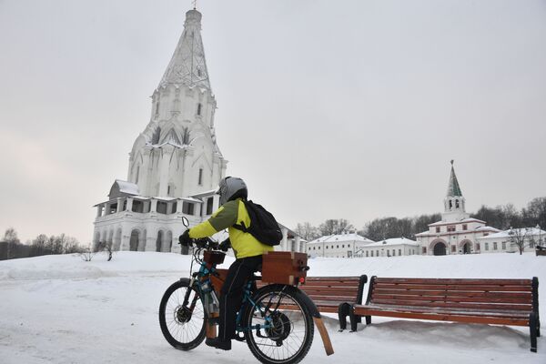 Молодой человек на велосипеде около церковки Вознесения Господня в парке Коломенское в Москве - Sputnik Латвия