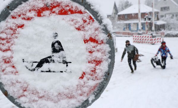 Люди на санках во время снегопада в Цюрихе - Sputnik Latvija