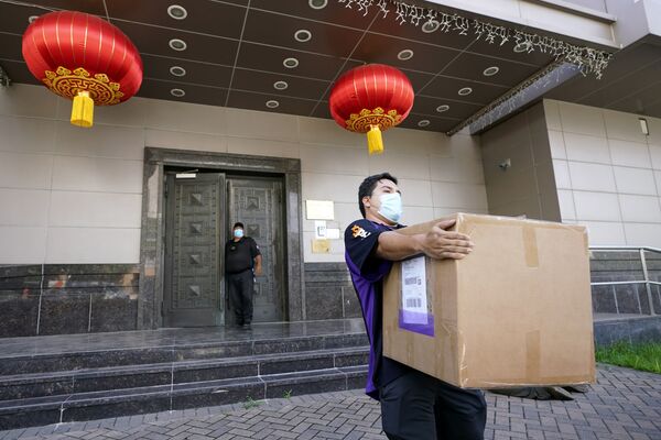 Сотрудник FedEx забирает ящик из китайского консульства в Хьюстоне Сотрудник FedEx забирает ящик из китайского консульства в Хьюстоне - Sputnik Латвия