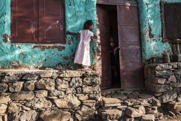 Девочка заглядывает в приоткрытую дверь в городе Гондар, Эфиопия - Sputnik Латвия