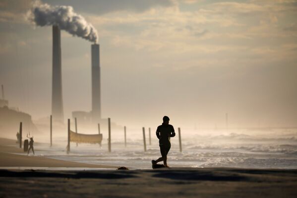 Мужчина бежит по пляжу в Ашкелоне во время третьего локдауна в Израиле - Sputnik Латвия