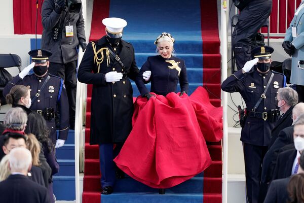 ASV himnu ceremonijā izpildīja Lēdija Gaga. Skatītājiem iespiedās atmiņā viņas tērps ar pieguļošu tumši zilu žaketi un kupliem sarkaniem svārkiem, tomēr uzmanības centrā bija liela apzeltīta broša – balodis, miera simbols ASV himnu ceremonijā izpildīja Lēdija Gaga. Skatītājiem iespiedās atmiņā viņas tērps ar pieguļošu tumši zilu žaketi un kupliem sarkaniem svārkiem, tomēr uzmanības centrā bija liela apzeltīta broša – balodis, miera simbols - Sputnik Latvija