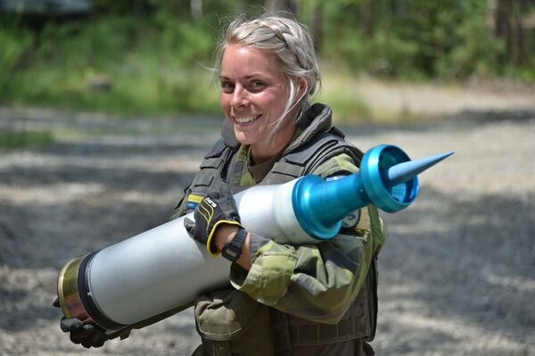 Женщина-военнослужащий армии Швеции несет снаряд во время танковых испытаний Strong Europe - Sputnik Латвия