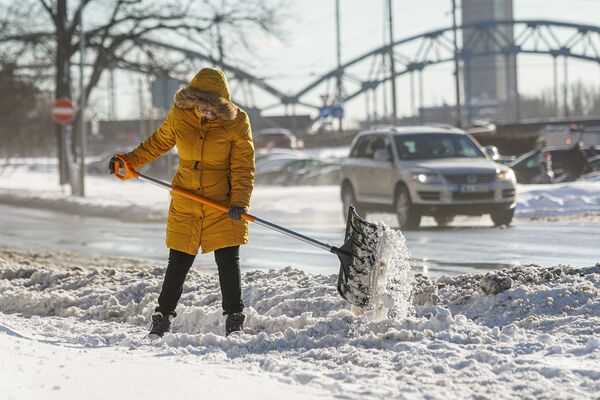 Женщина убирает снег - Sputnik Latvija