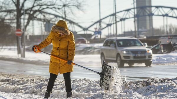 Женщина убирает снег - Sputnik Latvija