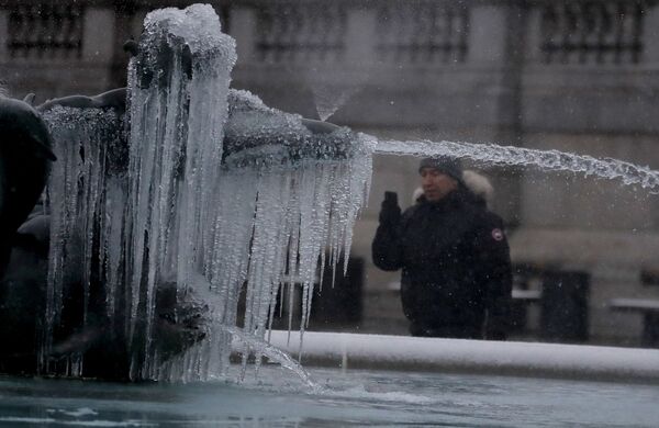 Мужчина фотографирует покрытую льдом статую на Трафальгарской площади в Лондоне - Sputnik Latvija