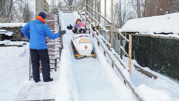 Aivis Bērziņš māj sievai un meitai, kamēr viņas vizinās pa paštaisīto bobsleja treku Aivis Bērziņš māj sievai un meitai, kamēr viņas vizinās pa paštaisīto bobsleja treku - Sputnik Latvija