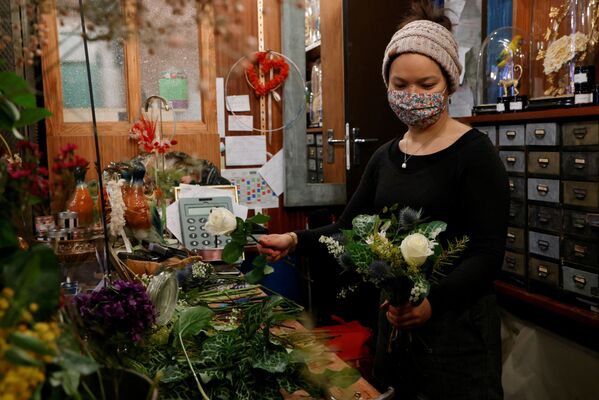 Цветочница в защитной маске собирает букет в цветочном магазине перед Днем святого Валентина в Париже, Франция - Sputnik Latvija