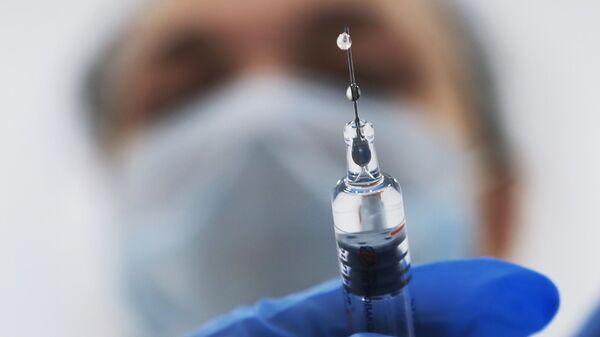 Медик готовит шприц с вакциной - Sputnik Latvija