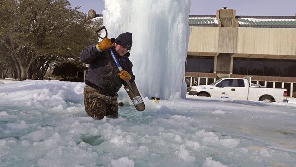 Рабочий ломает лед в замерзшем фонтане в Ричардсоне, штат Техас, США - Sputnik Latvija