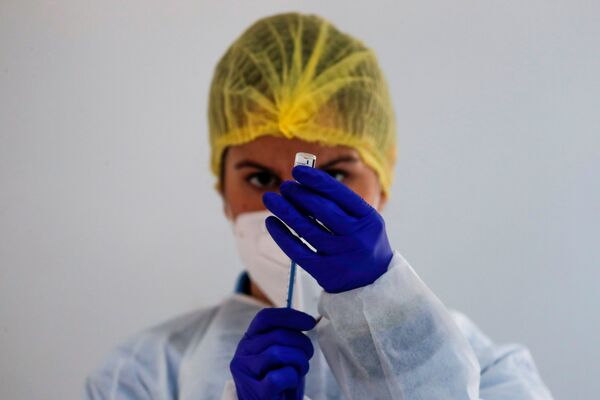 Mediķe gatavo Pfizer/BioNTech vakcīnu masveida vakcinācijas laikā Rondā, Spānijā Mediķe gatavo Pfizer/BioNTech vakcīnu masveida vakcinācijas laikā Rondā, Spānijā - Sputnik Latvija