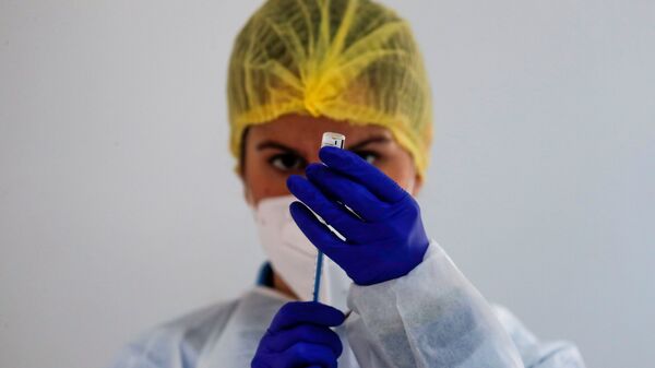 Медицинский работник готовит дозу вакцины Pfizer-BioNTech во время массовой вакцинации в Ронде, Испания - Sputnik Латвия