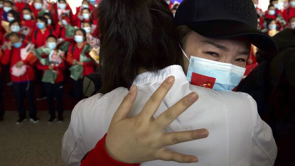 Медицинский работник из китайской провинции Цзилинь прощается с коллегами в международном аэропорту Тяньхэ в Ухане, Китай - Sputnik Latvija