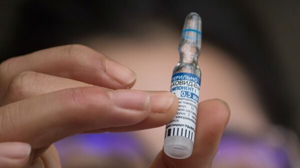 Медицинский работник демонстрирует ампулу с российской вакциной Спутник V (Гам-КОВИД-Вак) - Sputnik Латвия