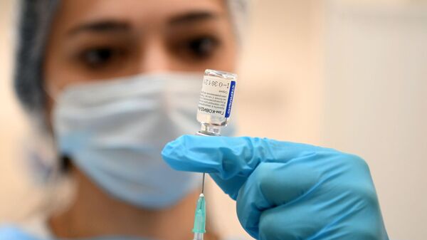 Медицинский сотрудник набирает в шприц российскую вакцину Спутник V (Гам-КОВИД-Вак) - Sputnik Латвия
