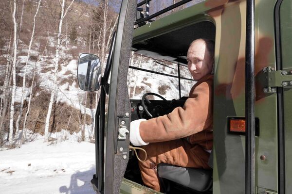Президент РФ Владимир Путин управляет вездеходом во время прогулки в тайге Президент РФ Владимир Путин управляет вездеходом во время прогулки в тайге - Sputnik Латвия