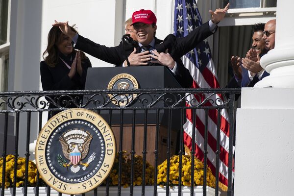 ASV prezidents Donalds Tramps apskāvis Washington Nationals beisbolistu Kurtu Suzuki pasākumā Baltajā namā par godu 2019. gada Pasaules sērijas čempionam  - Sputnik Latvija