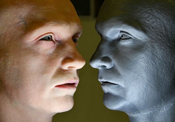 Kompānijas Promobot izstrādātā robota-humanoīda galva (no kreisās) līdzās modeļa galvai - Sputnik Latvija