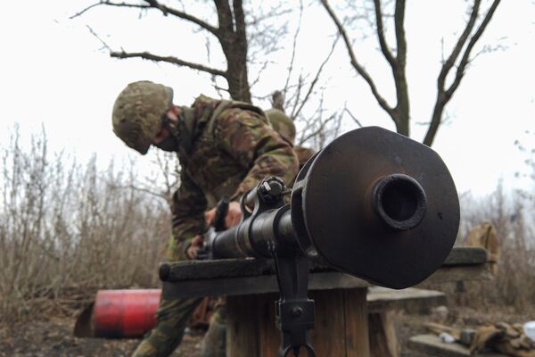 Ukrainas armijas kareivis tīra ieroci pozīcijās pie saskarsmes līnijas Doņeckas pilsētas apkaimē - Sputnik Latvija