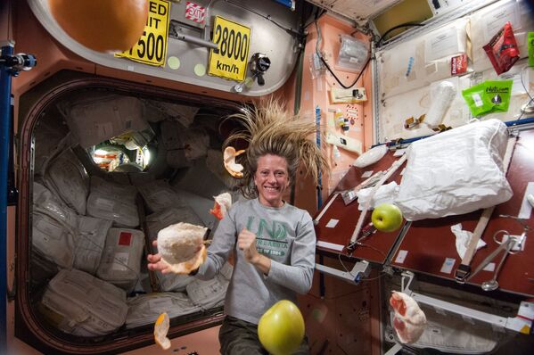 Американский астронавт Карен Найберг с летающими фруктами на МКС. - Sputnik Латвия