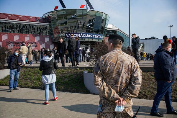 Люди стоят в очереди на прививку от COVID-19 в Риге. Люди стоят в очереди на прививку от COVID-19 в Риге. - Sputnik Латвия