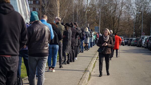Люди стоят в очереди на прививку от COVID-19 в Риге - Sputnik Латвия