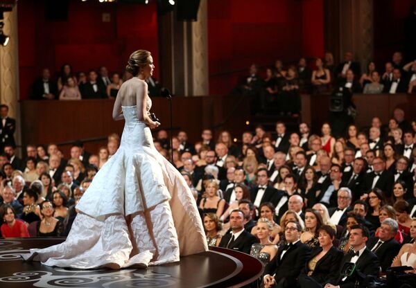 Дженнифер Лоуренс на церемонии вручения премии Оскар, 2013 год. Нежнейшее розовое творение от Christian Dior - самое дорогое платье за всю историю Оскара. И то, что актриса оступилась, поднимаясь в пышном платье на сцену за заветной статуэткой, сделала его только дороже. - Sputnik Латвия