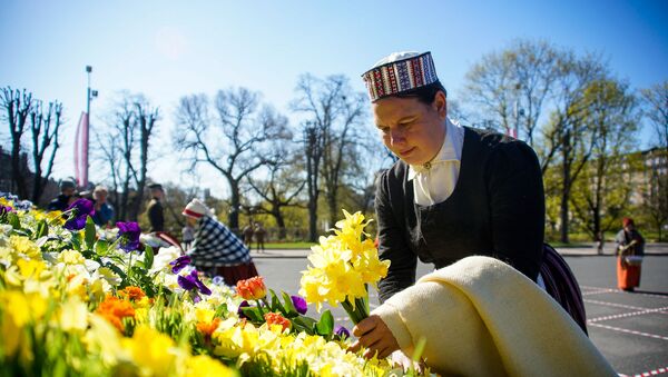 Женщина в национальном костюме принесла цветы к памятнику Свободы в День восстановления независимости Латвии - Sputnik Латвия
