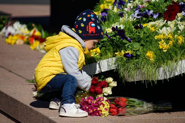 Bērns ar rozēm Latvijas karoga krāsās pie Brīvības pieminekļa Latvijas neatkarības atjaunošanas dienā Bērns ar rozēm Latvijas karoga krāsās pie Brīvības pieminekļa Latvijas neatkarības atjaunošanas dienā - Sputnik Latvija