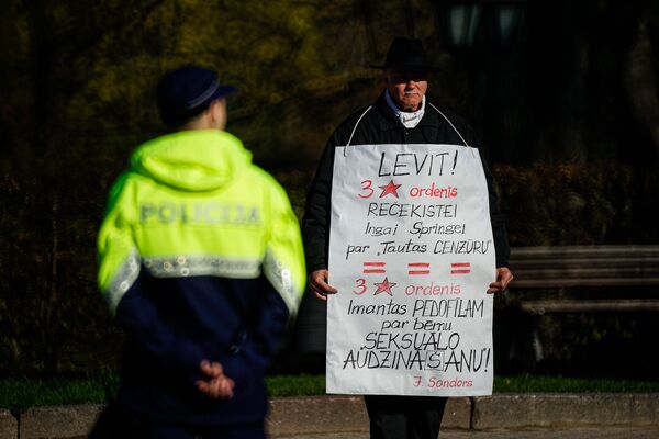 Latvijas antiglobālists Sigurds Graudiņš ar plakātu Latvijas neatkarības atjaunošanas dienā Latvijas antiglobālists Sigurds Graudiņš ar plakātu Latvijas neatkarības atjaunošanas dienā - Sputnik Latvija