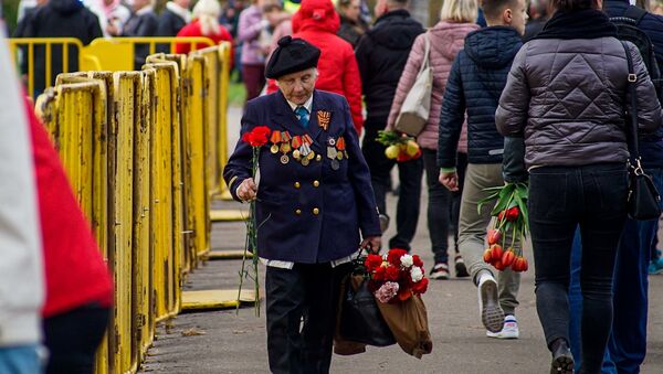 Люди идут, чтобы возложить цветы к памятнику Освободителям Риги - Sputnik Латвия