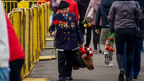 Cilvēki dodas nolikt ziedus pie Uzvaras pieminekļa Rīgā - Sputnik Latvija