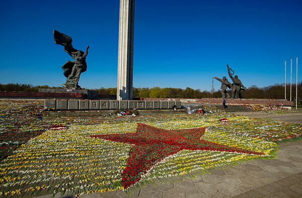 Sarkanā zvaigzne no ziediem pie Uzvaras pieminekļa, ko izkārtojuši brīvprātīgie Sarkanā zvaigzne no ziediem pie Uzvaras pieminekļa, ko izkārtojuši brīvprātīgie - Sputnik Latvija