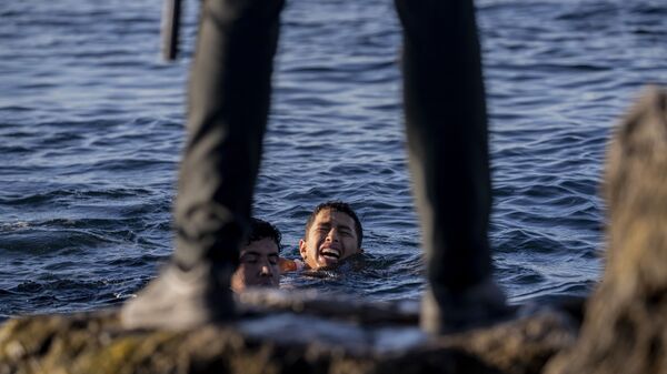 Представитель Испанской гражданской гвардии ожидает мигрантов на берегу в испанском анклаве Сеута, недалеко от границы Марокко и Испании - Sputnik Latvija